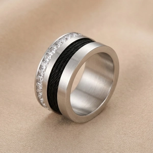 Macro detail of wide ring featuring cubic zirconia, black cable texture, and brushed steel