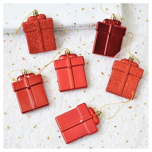 Detail of red Christmas gift box ornaments with glitter and shiny finish on white tulle