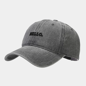 Close-up of HELLO embroidery and vintage washed texture on dark gray cotton baseball cap