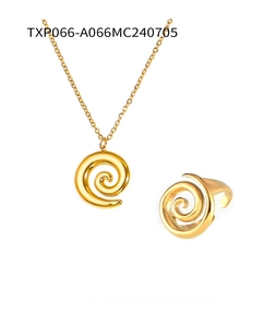 Macro shot of gold-tone titanium steel jewelry set featuring spiral twist necklace and ring