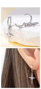 Detail of silver hoop earrings with zircon cross pendants in white, pink and blue stone