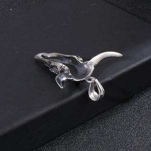 Detailed view of punk style stainless steel bull skull pendant on a textured background