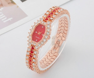 Detail of rose gold quartz watch featuring a red dial and sparkling rhinestone crystals