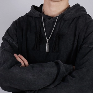 Silver comb pendant necklace on a twist chain worn by a male model in a black hoodie