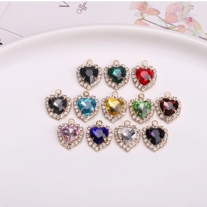 Flat lay of colorful heart pendants in twelve shades with rhinestone gold plating