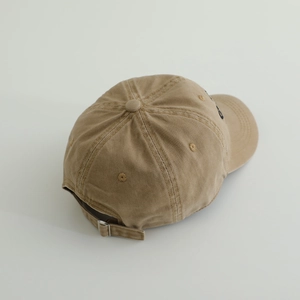Dettaglio della fibbia in metallo regolabile e ricamo sul cappello in cotone kaki