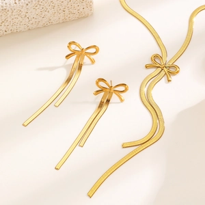 Details des goldenen Schleifen-Schmucksets mit langer Quaste, Kette und Ohrringen