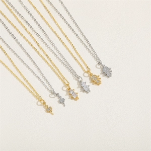 Detail of elegant ballerina girl pendants with zircon stones on thin 14K gold plated chains