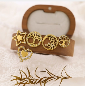Macro shot of gold stainless steel pendants with tree of life and heart crystal details