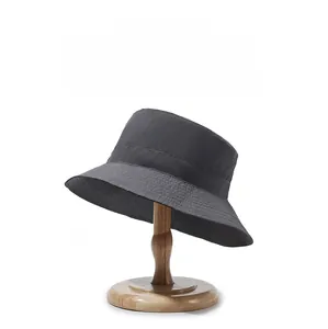 Détail d'un chapeau de soleil gris foncé imperméable sur un support en bois
