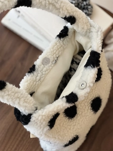 Détail d'un sac en laine d'agneau à pois, fermeture magnétique et poche intérieure