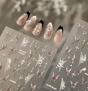 Dettaglio di adesivi per unghie con farfalle e stelle su manicure francese nera