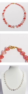 Detail of heart-shaped stone beaded necklace with baroque pearl and gold lobster clasp