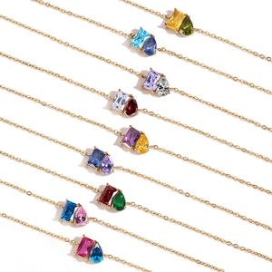 Detail of 14k gold necklaces with dual emerald and pear-cut crystal pendants