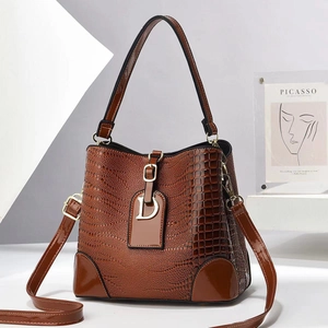 Brown crocodile embossed bucket bag with glossy finish and golden metal D pendant