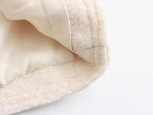 Détail de la veste bouclée beige avec texture sherpa douce et doublure en satin