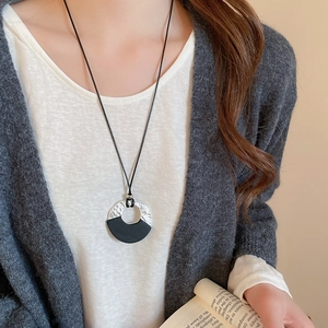 Detail of vintage geometric wood necklace with silver texture on long wax rope cord