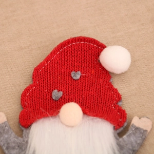 Close-up of Christmas gnome utensil holder showing red knitted hat and plush white beard