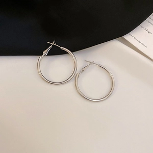 Macro view of geometric silver hoop earrings in a minimalist C-shape design