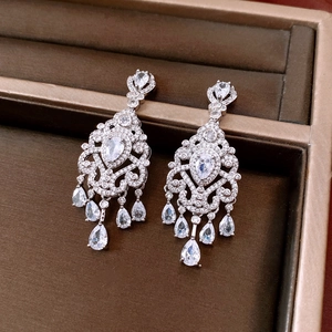 Detailed macro view of silver chandelier earrings with zircon tassels in a jewelry box