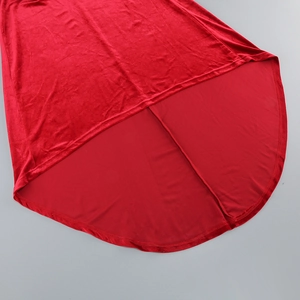 Détail d'une robe en velours rouge avec ourlet asymétrique et texture de tissu de luxe