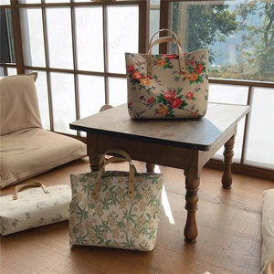 Detail of vintage floral tote bags with reinforced leather handles in a cozy interior