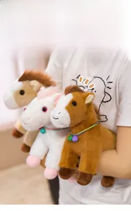 Detail of plush pony toy showing soft texture and bell collars held in arms