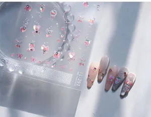 Detail of pink strawberry and bow nail stickers with rhinestones for nail art