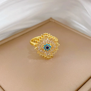 Detailed macro view of rotating evil eye ring with blue stone and turquoise beads