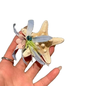 Starfish hair claw clip with floral ornaments and blue gemstone for summer hair styling