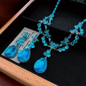 Vue détaillée d'une parure de bijoux de luxe avec collier et boucles d'oreilles goutte bleu roi