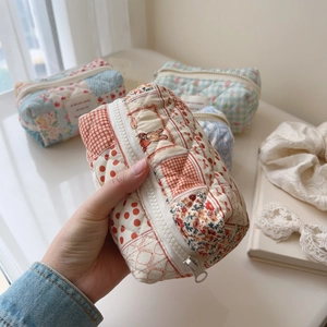 Close-up of quilted floral and checkered cotton makeup bags with a secure zipper closure
