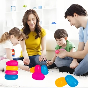 Family playing with colorful pebble-shaped stacking sensory toys on a living room rug