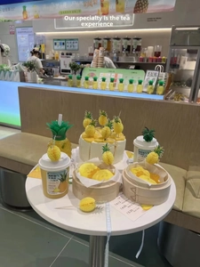 Close-up of decorative pineapple picks and themed desserts for a tropical party setup
