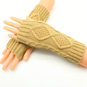 Close-up of beige cable knit fingerless gloves with classic braided texture pattern
