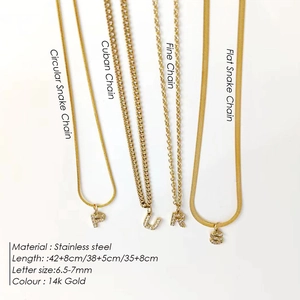Four 14k gold plated stainless steel letter necklaces with various snake and cuban chains