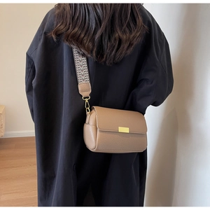 Sac bandoulière marron en cuir texturé vintage avec une sangle géométrique tissée