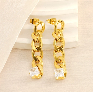 Detail showing long gold-plated chain earrings with square white zircon stones