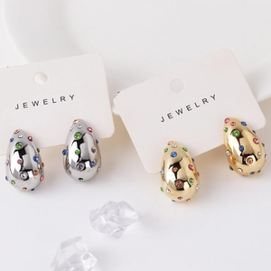 Dettaglio di orecchini a goccia con pietre di zirconia multicolore in oro e argento