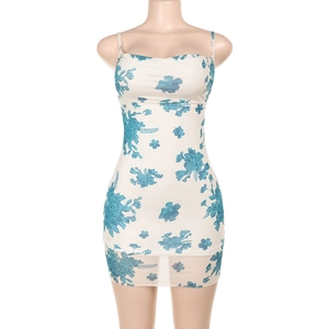 Detalle del estampado floral azul en un vestido mini blanco con tirantes finos y cintura