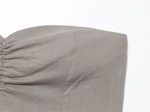Detail of grey linen blend fabric showing texture and gathered pleat craftsmanship