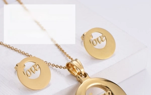 Macro view of gold-plated titanium steel jewelry set featuring hollowed-out LOVE engravings