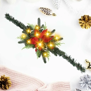 Close-up of lighted Christmas garland with red poinsettia and warm LED lights