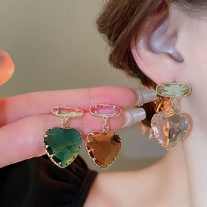 Close-up of heart-shaped crystal drop earrings in green, orange, pink, and purple colors