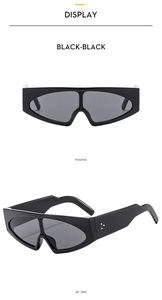 Close-up of black geometric sunglasses featuring three gold rivets on wide temple arms