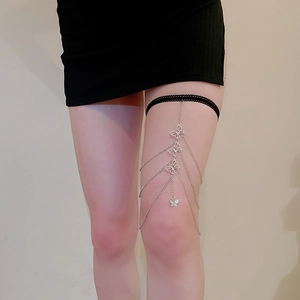 Close-up of three-layered silver leg chain with hollow butterfly charms and black lace