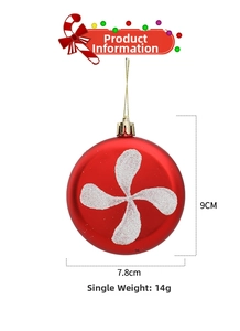 Detail of red matte Christmas ornament with white glitter swirls and gold hanging cord