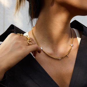 Ensemble collier en acier titane doré et bagues en zircon sur le cou et la main