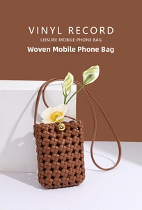 Detail of woven phone bag in dark brown with gold round twist lock and floral decor