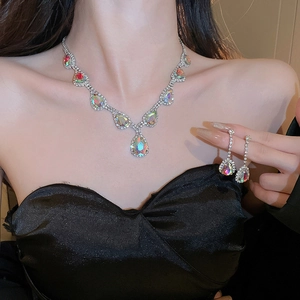 Modella che indossa collana e orecchini a goccia in argento con perle iridescenti